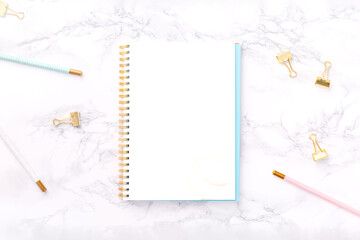 Festive golden stationary on white marble background. Feminine job, gender equality, home office, work from home and career concept. Copy space Top view. Horizontal