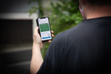 User mit der offiziellen Corona-Warn-App auf dem iPhone