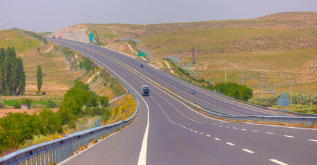 Curve asphalt highway road among the golden wheat field