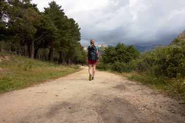 Obraz premium Woman with a backpack walking alone in the mountain, hiking. Concept of freedom