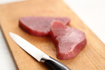 Raw tuna steak on wooden cutting board
