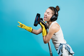 housekeeper sings in a brush from a vacuum cleaner, listening to music