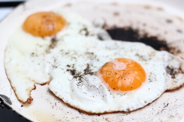 Sunny side up eggs with black pepper and salt