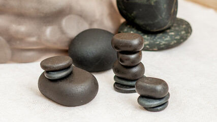 Set of stacks hot massage stones on towel in spa.