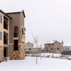 Square Apartments and houses against snow covered landscape and cloudy sky in winter