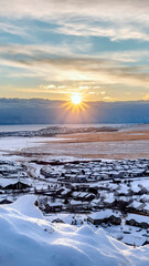 Vertical frame Beautiful sunrise in Draper Utah with snowy hills lake and houses in winter