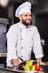 Male chef at kitchen restaurant. Portrait of smiling male cooker.