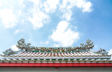 Fototapeta na wymiar Orienatal Chinese traditional pattern roof wall under bright blue sky and clound background 
