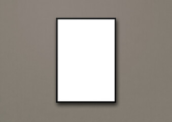 Black picture frame hanging on a dark grey wall
