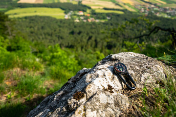Travel concept photo of compass  placed on the rock in Hohe Wand Nature Park. Lower Austria, June 2020.