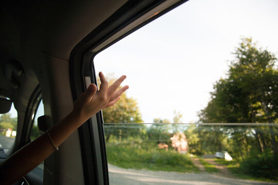 Kid Hand Reaching Out Of A Car Window.