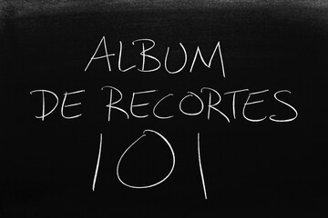 The words Album De Recortes 101 on a blackboard in chalk.  Translation: Scrapbooking 101