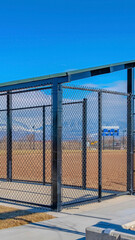 Vertical Baseball field dugout with slanted roof and chain link fence on a sunny day