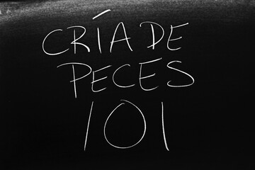 The words Cría De Peces 101 on a blackboard in chalk.  Translation: Fish Farming 101