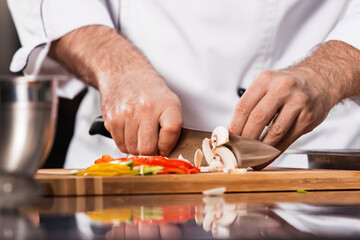 Obraz na płótnie Canvas Chef hands cut food at kitchen. Closeup chef hands cut mushroom.