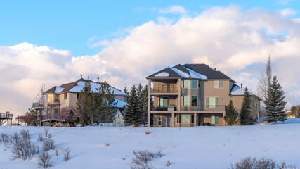 Fototapeta na wymiar Panorama Homes against clouds and blue sky at Wasatch Mountains neighborhood in winter