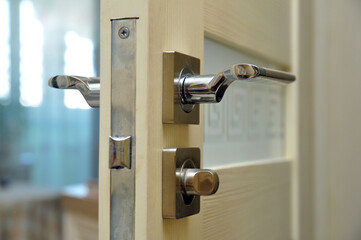 Modern style doorknob on a wooden door. Door lock