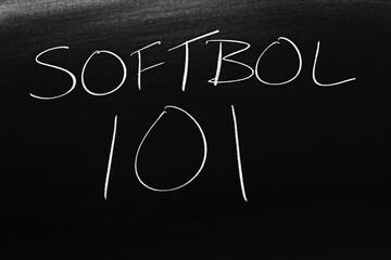 The words Softbol 101 on a blackboard in chalk.  Translation: Softball 101