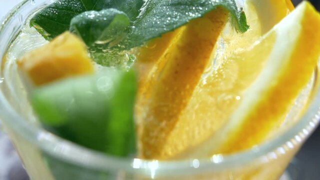 A refreshing soft drink. Mojito is poured into a glass close-up. Lemon mint and sparkling water with ice.
