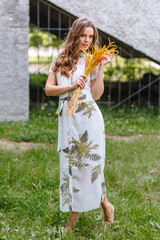 A girl in a light summer dress with a bouquet of yellow flowers, on the street