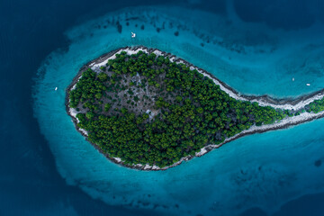Aerial view of a round peninsula in blue sea water