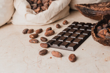 Dark natural chocolate and cocoa beans on the table. Chocolate production concept