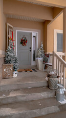 Vertical Wet stairs at home entrance leading to front door with christmas tree and wreath