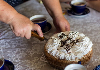 Cutting a portion of carrot cake after have spilled a tea cup for breakfast