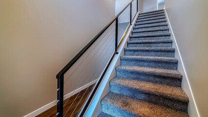 Panorama Indoor stairs of home with metal handrail and gray carpet on the treads