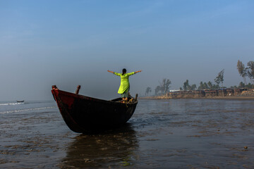 Fototapeta premium An woman standing on a boat on a sea beach