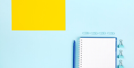 School office supplies on blue background. Back to school concept. Geometric composition. Top view. Copy space