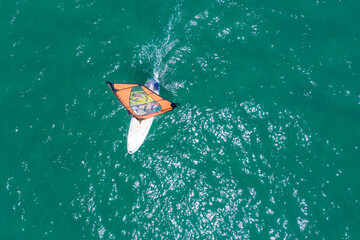 Windsurfer cruising across the open Sea, Aerial image.