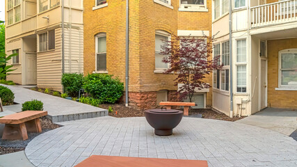 Fototapeta na wymiar Panorama Stone benches around fire pit outside of a residential building complex