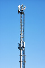 Cellular antenna tower on background of blue sky.