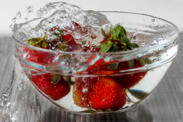 Strawberries falling in water with spray