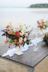 Fototapeta na wymiar Beautiful wedding wooden table on the nature. Stylish wedding flower decor. wedding flowers on the tabl