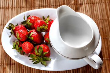 Strawberry on a tray with milk jug