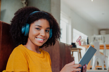 Portrait of beautiful young girl studying or working from home with her digital tablet and headphones 