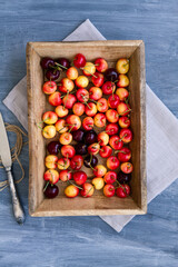 Fresh ripe cherries in a wooden tray with copy space. Top view composition