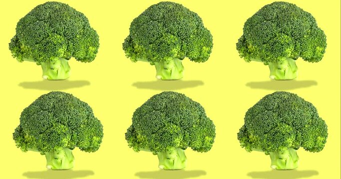 many green broccoli on yellow background moving. Video animation of ripe vegetables. template for advertising