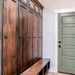 Square Panelled fire door with black knobs and lock adjacent to a tall vintage cabinet