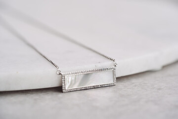 Pendant with a piece of marble in the middle, framed with crystals. 