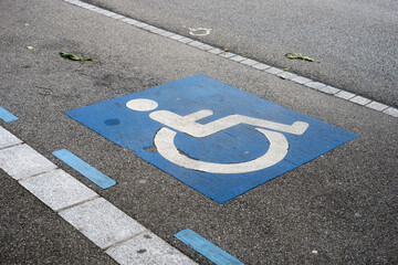 Closeup of painted blue symbol of invalid area parking in the street