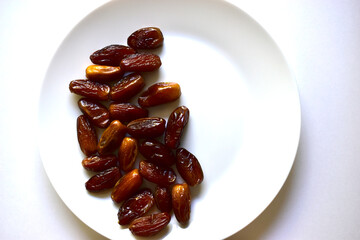 Ripe and delicious dates on a white plate