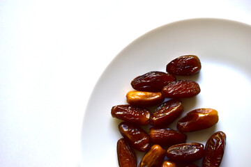 Ripe and delicious dates on a white plate