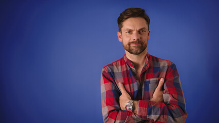 Handsome Caucasian Man with crossed arms smiling isolated on the blue background. High quality 4k footage