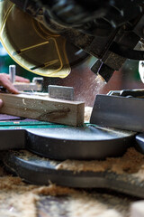 Obraz na płótnie Canvas Cutting lumber with sliding compound miter saw outdoors. Home carpentry workshop