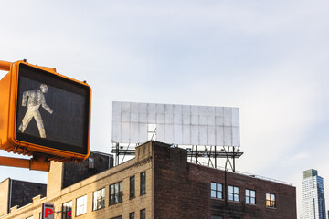 pedestrian traffic light and empty billboard on a roof under white sky