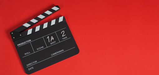 Fototapeta na wymiar Clapperboard or clap board or movie slate .It is use in video production ,film, cinema industry on red background.