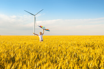 Little girl runs in a wheat field with a kite